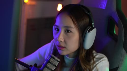 Gamer e E-Sport online de mulher asiática jogando vídeo de computador online com efeito de iluminação