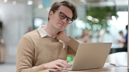 Young Adult Rubbing Stiff Neck While Working