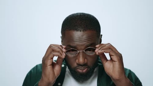 Man puts on fashionable wired rim sunglasses