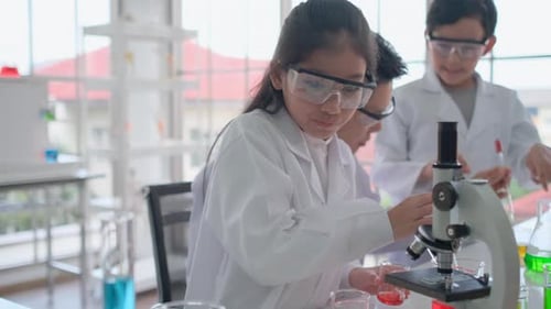 Close up young scientist junior or kids girl has fun with mixing the colorful chemicals