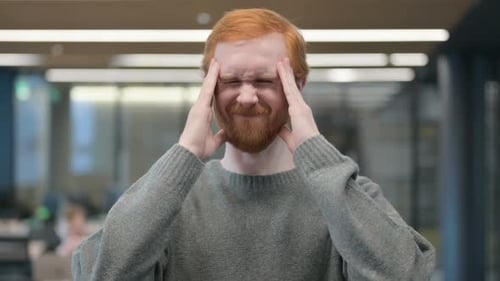 Adult Man Rubbing Temples in Office Setting