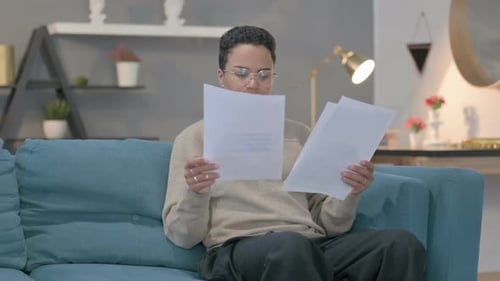 Adult Reading Documents While Sitting on Couch