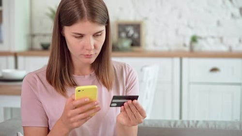 Woman Using Smartphone and Credit Card at Home