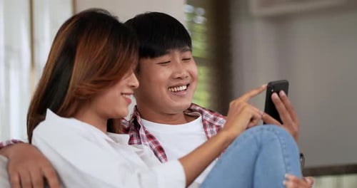 Smiling Couple Relaxing with Phone Indoors