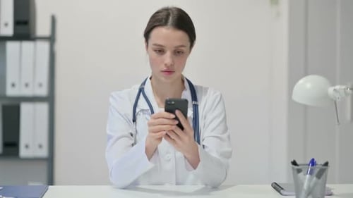 Young Doctor Using Smartphone in Office