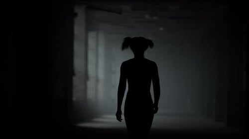 Silhouette Figure Walks Through Hallway