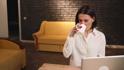 Young Woman Works on Laptop at Home Office