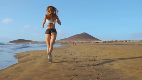 Woman Athlete Silhouette Running on Beach Sprinting Waves Crashing on Seaside Morning Background