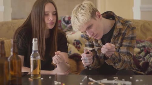Young Bad Looking Woman and the Man Using Drugs at Home