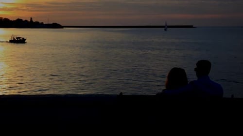 Silhouette of Talking Couple on Bench in Front of the Sea