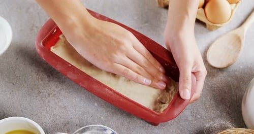 Hands Shaping Dough in a Loaf Pan