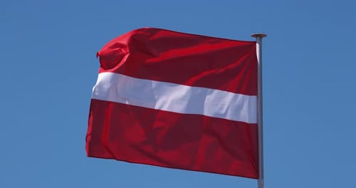 Latvian Flag Waving Against a Clear Blue Sky
