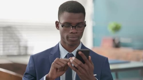 Young Adult Texting on Smartphone in Office