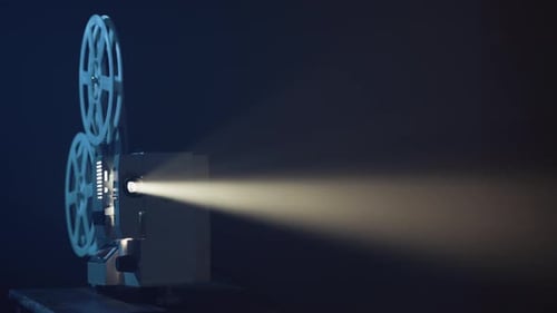 Antique Film Projector Shining Light in Dark Room