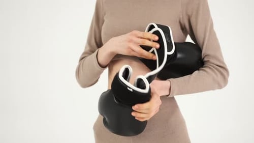 Woman in Sportswear Putting on the Black Gloves and Preparing for Training