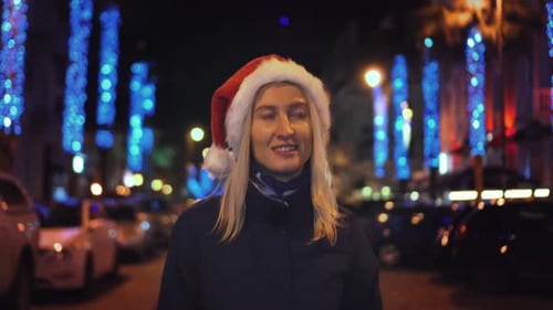 Woman with Santa Hat in Christmas City at Night