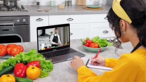 Mujer en casa, cocina, estudio, videollamada en línea, cámara web, computadora portátil, escucha, chef, profesor
