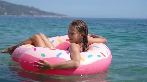 Adorable Girl on Inflatable Air Mattress in the Sea