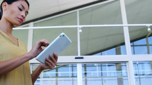 Woman Uses Tablet in Modern Urban Setting