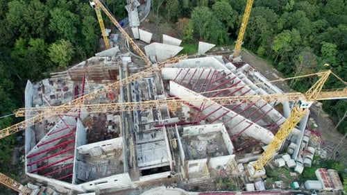 Vista aérea Construcción de un nuevo edificio con grúas torre altas en área verde