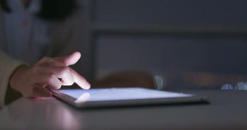 Woman use of tablet computer at night