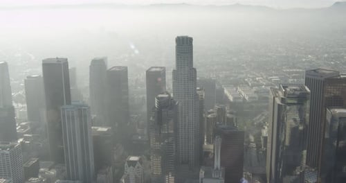 Helicopter aerial moving through clouds over green mountain landscapes, day