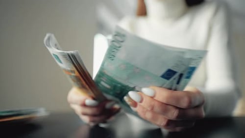 A Woman Is Holding Money and Counting Euro Bills