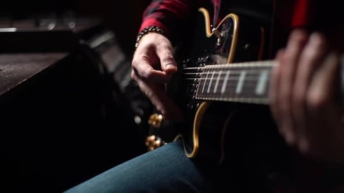 Closeup of Hands of Unrecognizable Musician Playing Solo Guitar Part on Electric Guitar at Studio