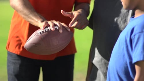 Man Explains Football to Child Outdoors