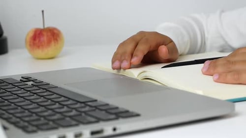 Hands Writing in Notebook with Laptop and Apple