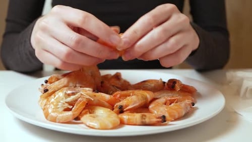 Person Peeling and Eating Delicious Shrimp