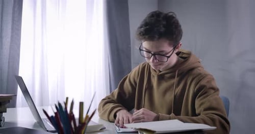 Close-up of Disappointed Caucasian Brunette Boy Tearing Off Workbook Page, Crumpling It and Throwing
