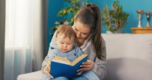 Mother Reads a Book with Infant at Home