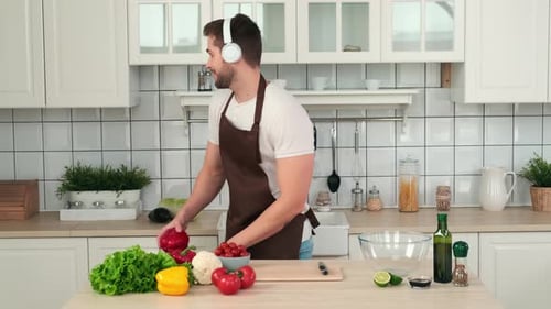 Man With Headphones Prepares Healthy Meal at Home