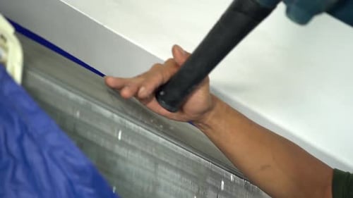 technician service using electric blowers to dry up and dust cleaning the air conditioner