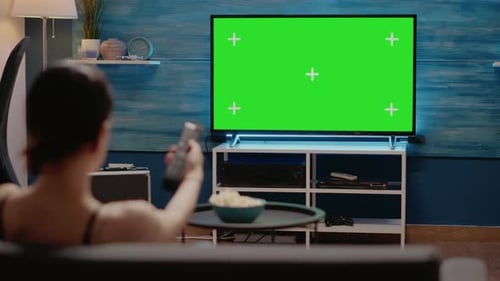 Femme caucasienne regardant la télévision avec écran vert