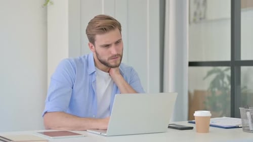 Man Working on Laptop in Bright Modern Office