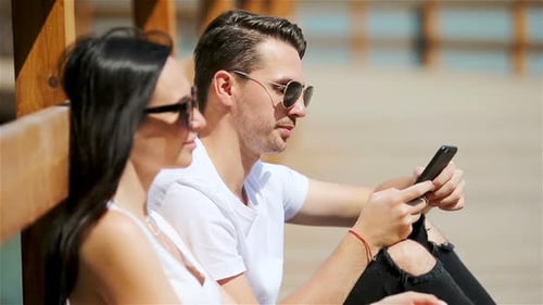 Picture of a Joyful Couple Using Smartphones in the Park