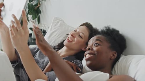 Queer Couple with Tablet Enjoying Lazy Morning