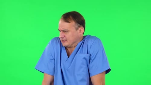 Un médecin s'est figé et a essayé de se réchauffer contre un écran vert.