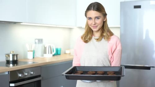 Woman Holding Tray of Fresh Baked Cookies in Kitchen