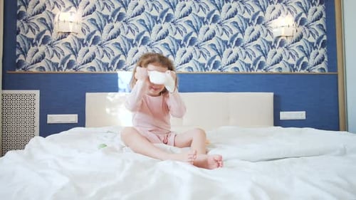 Happy Girl Wearing Bunny Ears on Bed