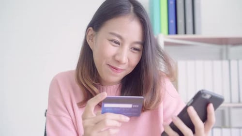Woman Using Credit Card with Mobile Phone