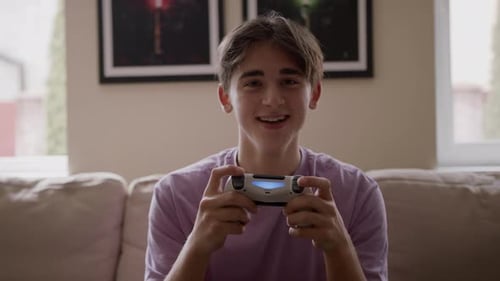 Enthusiastic Teen Playing Video Game at Home
