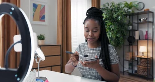 Woman with Dark Skin Professional Vlogger or Blogger Recording with Ring Light Contouring Makeup