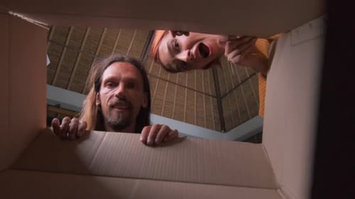 Happy People Look Inside Cardboard Box Indoors