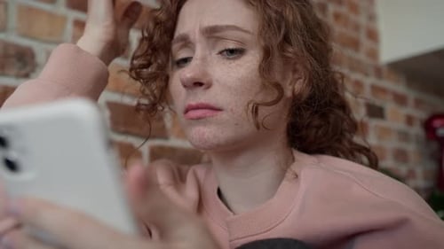 Close up low angle video of young caucasian woman using mobile phone.