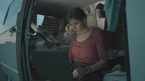 Woman Works on Laptop Inside Cozy Camper Van