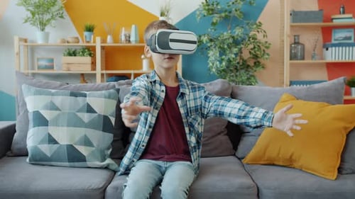 Boy Experiences Virtual Reality on Couch at Home