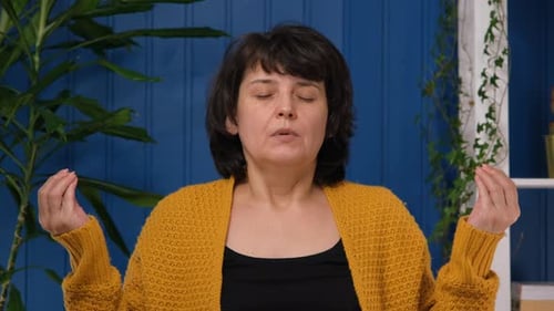 Middle Aged Woman Meditation and Relaxation at Home in Pose Lotus